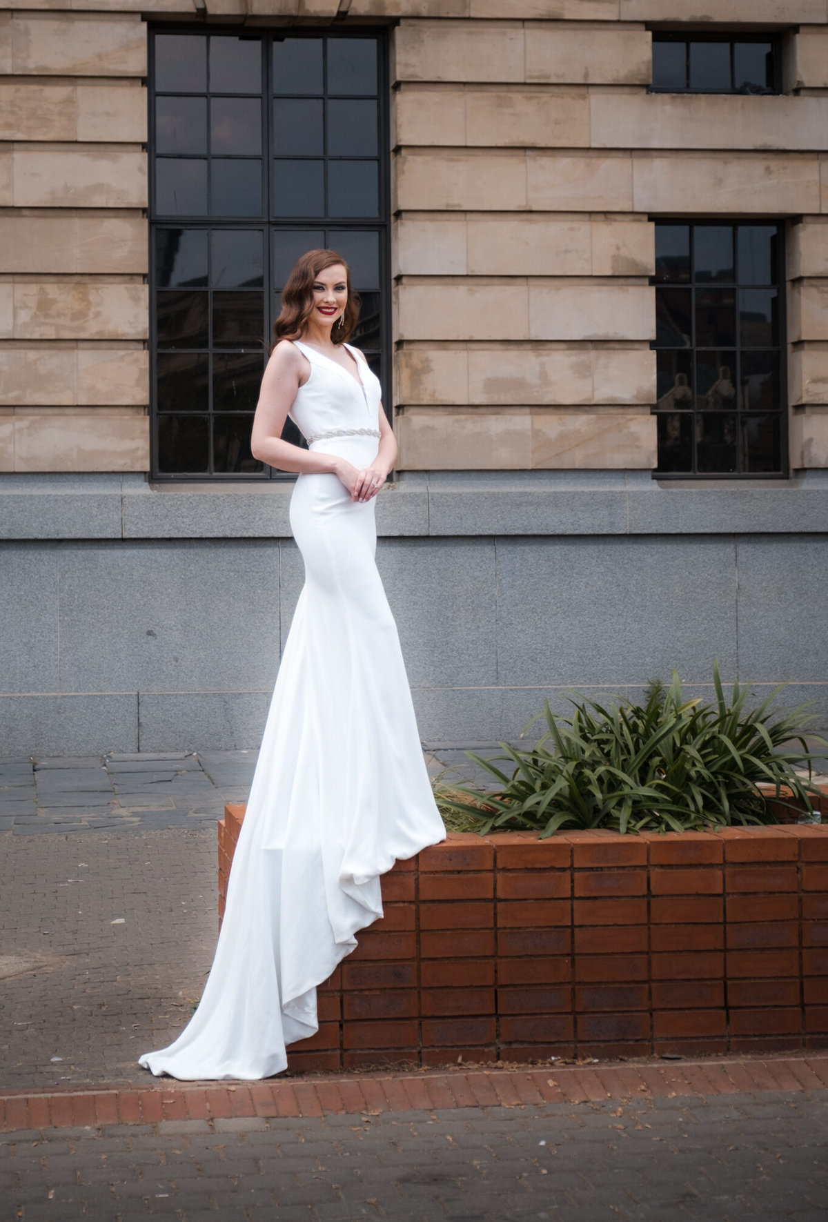 Bride, Chane wearing the Diana gown from Fynbos bridal with a long train standing on a flower bed in Pretoria City