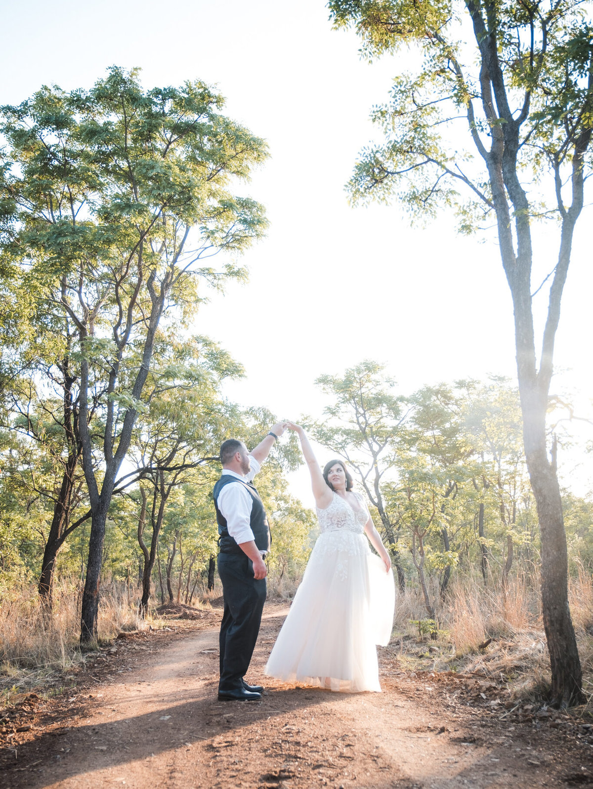Photo by Lynette van der Bijl On a rustic farm wedding at Kuthaba Lodge near Warmbath, the bride and groom dancing on a dirt road.