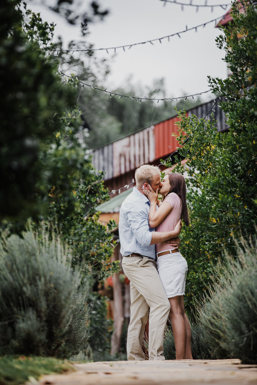 Riekie and Divan kissing in front of the reception hall at Nice To Meat You in Kempton Park